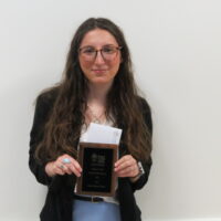 Student holding a school of business academic award