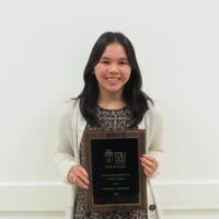 Student holding a school of business academic award