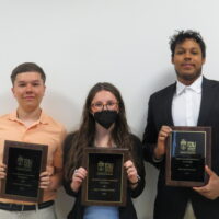 3 Students holding a school of business academic award