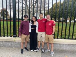 A group of people standing next to each other in front of a white building