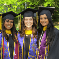 A close up of three people at commencement