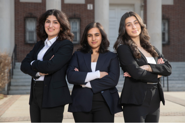 three women in black business suits standing with their arms crossed